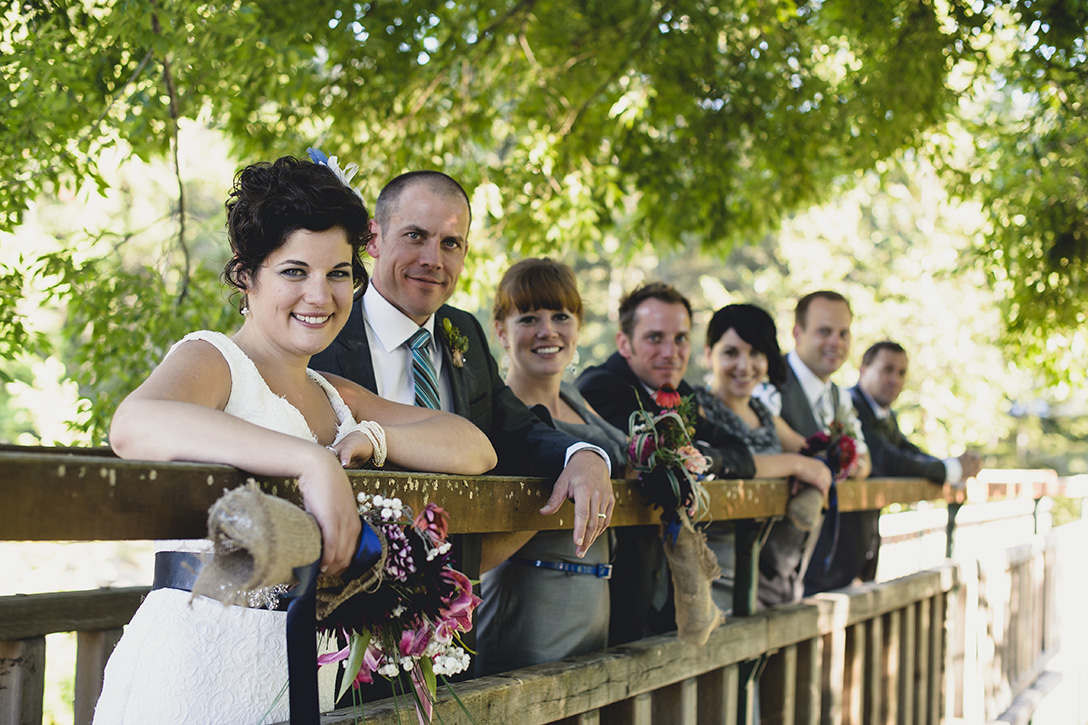 The wedding party on footbridge at rustic Kootenay Wedding by Electrify Photography.